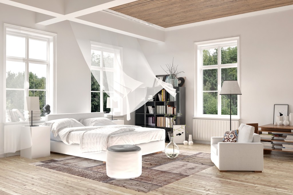 Bright white luxury rendered bedroom interior with blowing curtains on tall windows above a comfortable double bed with seating and a bookcase on a painted white wood floor. 3d Rendering